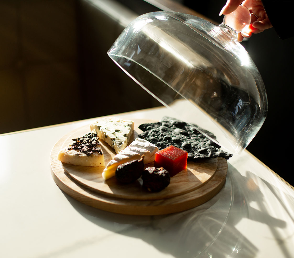 An assortment of Spanish dishes arranged on a table with a narrow depth of field, with drinks and various small sharing plates nestled between the large dishes.