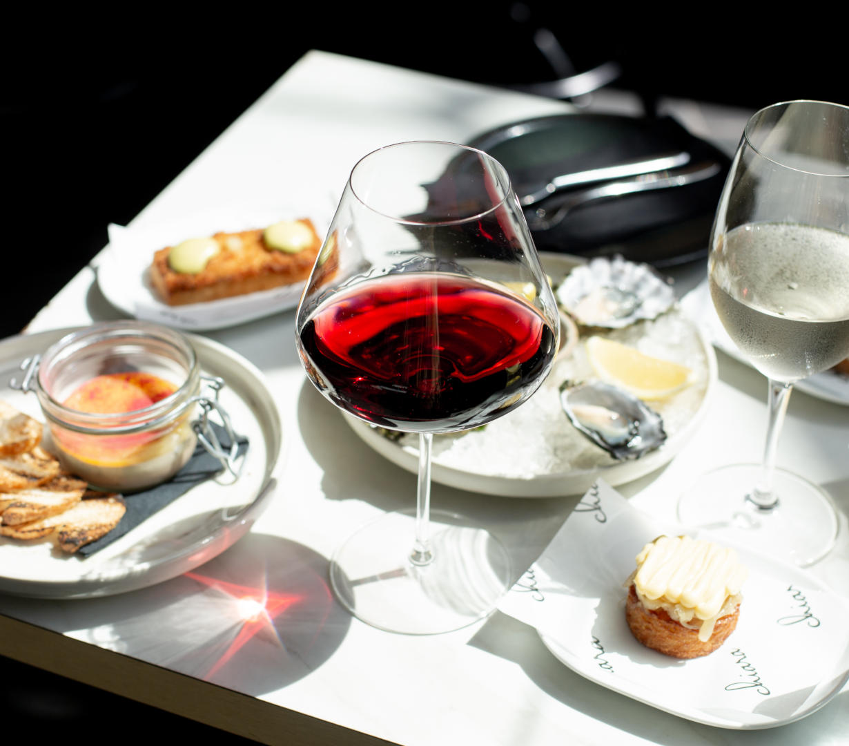 An assortment of small Spanish sharing plates and drinks arranged on a table with a narrow depth of field.